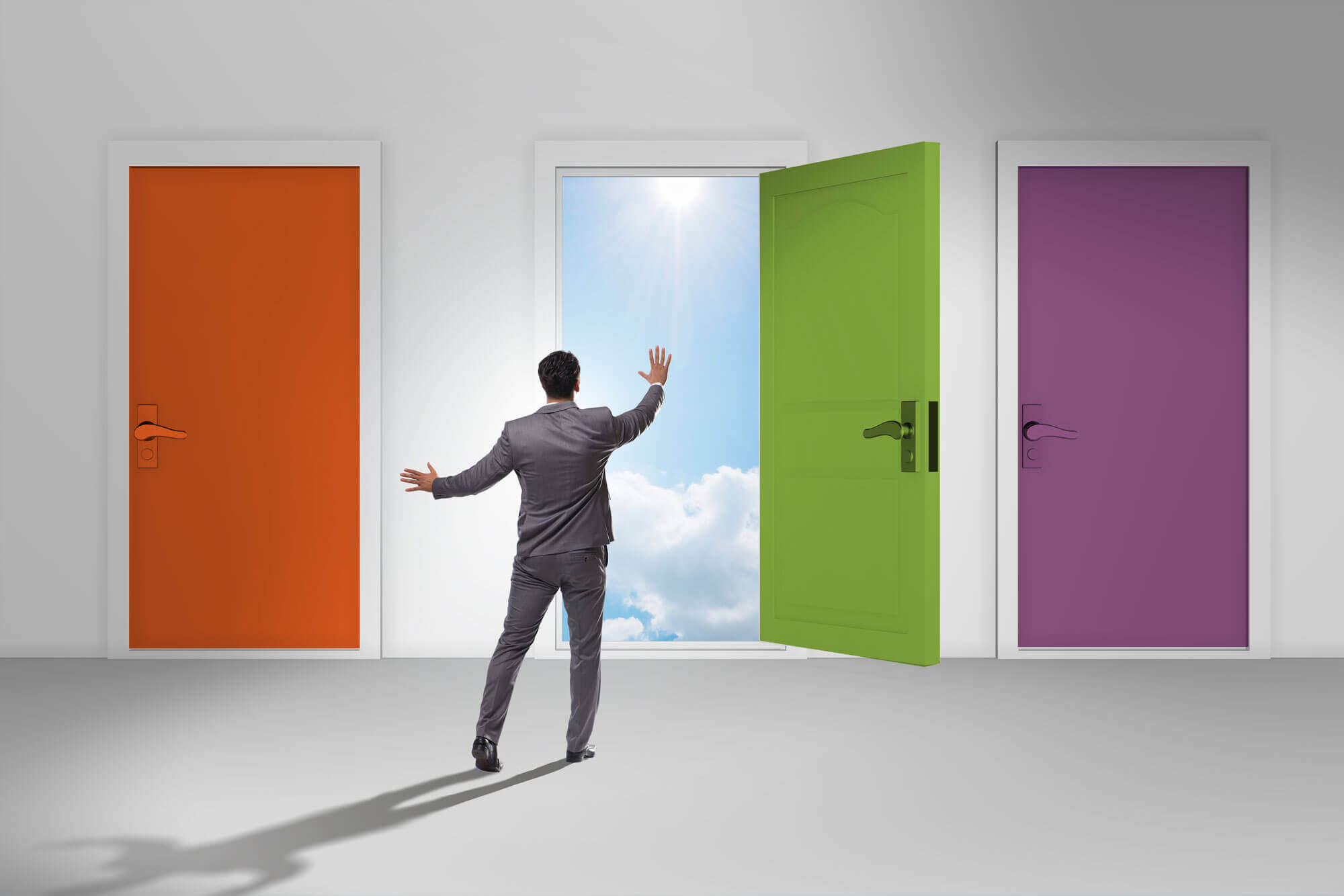 man dressed in a suit going to one of the three colored doors. the open door shows the sky with clouds