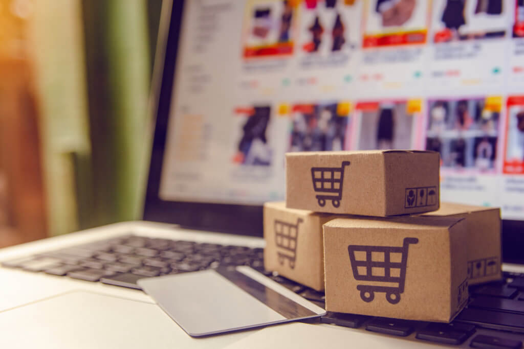 laptop with ecommerce with boxes and credit card. Why Your Shopify Store Needs a Code Cleanup
