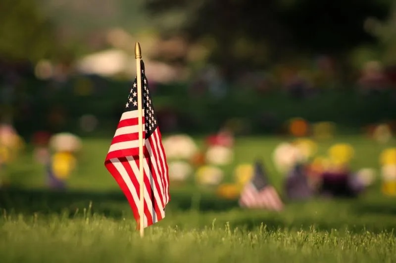 American flag planted in a cemetery, honoring fallen soldiers.