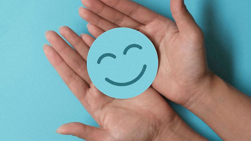 Hands holding blue circle with a smiling face, blue background