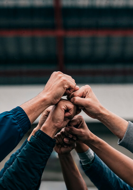 Teamwork in action: multiple hands stacked in unity with a blurred background