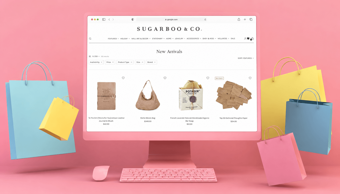 Sugarboo & Co. website on a pink monitor, showcasing new arrivals with shopping bags.